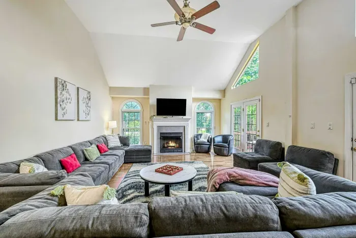 Living Room - Vaulted ceiling with arched windows, gas fireplace, Smart TV, and oversized sectional for the whole group.