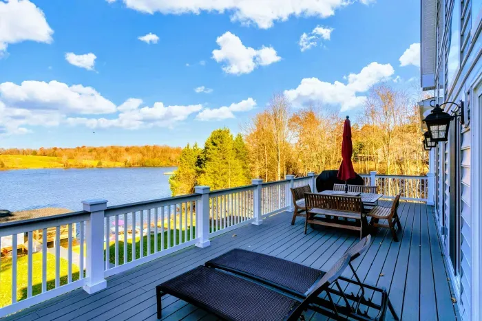 Spacious deck with dining and lounge areas, offering stunning views of the lake and surrounding nature