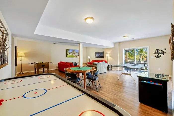 Spacious game room with air hockey, foosball, ping pong, and a poker table for ultimate indoor entertainment