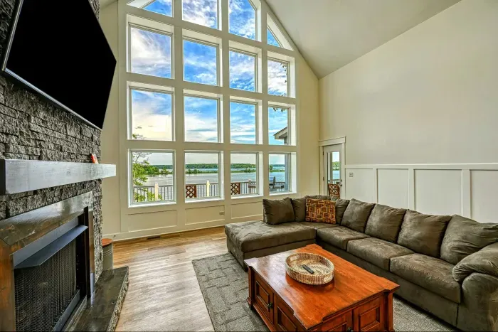 Bright and spacious living room with a floor-to-ceiling window offering breathtaking lake views, perfect for relaxing