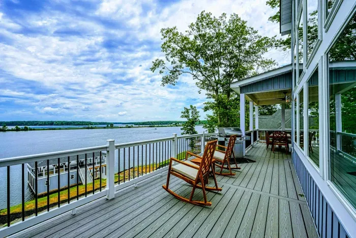 Expansive deck with rocking chairs offering serene, panoramic lake views for the ultimate outdoor relaxation experience