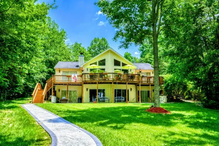 Lakefront Elegance at Lake Anna – This stunning home, surrounded by lush foliage and a vast lawn, features expansive decks with spectacular views, creating a perfect haven for leisure and lakeside enjoyment.