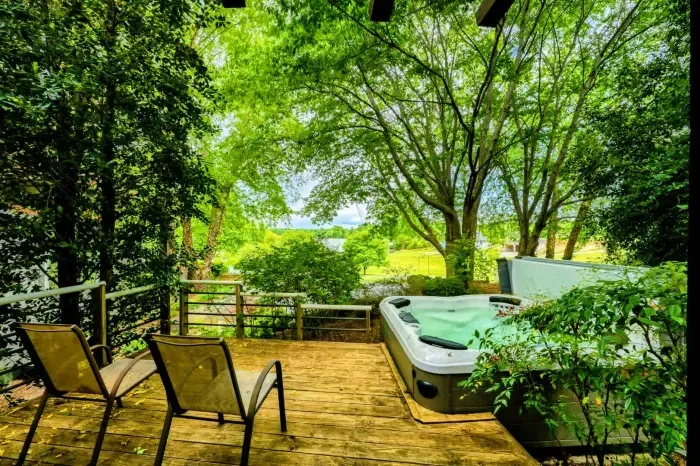 Soothe your senses in the private hot tub surrounded by lush greenery, a perfect spot to relax after a day of adventure.