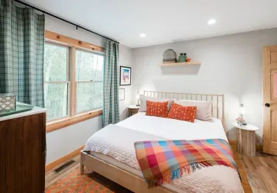 Morning light filters through plaid curtains and pink accents in “Ski Bunny’s Boutique.” Soft textures, playful color, and a touch of whimsy make this room feel like a gentle pause between mountain adventures.