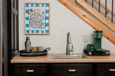 Morning coffee or evening cocktails... this basement wet bar is ready for both. With a sink, glassware, and a pop of color, it’s the perfect little corner to fuel the fun downstairs