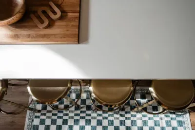 It’s the little details that bring this kitchen to life—warm brass stools tucked under a spacious island, a patterned runner adding a pop of camp-inspired charm, and plenty of room to gather, snack, and linger