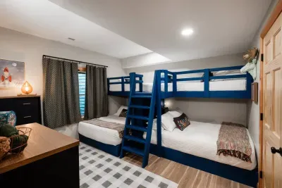 Custom-built bunks feature queen beds on the bottom (perfect for parents, grandparents, or friends who want a bit more space) and twin bunks up top, ready for cousins, besties, or anyone who loves to climb the ladder into their own little hideaway