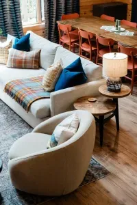 A deep Crate & Barrel sofa layered with bold textiles, swivel chairs made for settling in, and a dining table that can handle both game night and pancake brunch. This is where the day unwinds and conversation flows