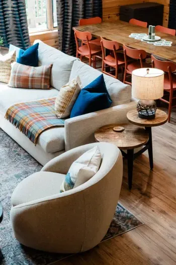 A deep Crate & Barrel sofa layered with bold textiles, swivel chairs made for settling in, and a dining table that can handle both game night and pancake brunch. This is where the day unwinds and conversation flows