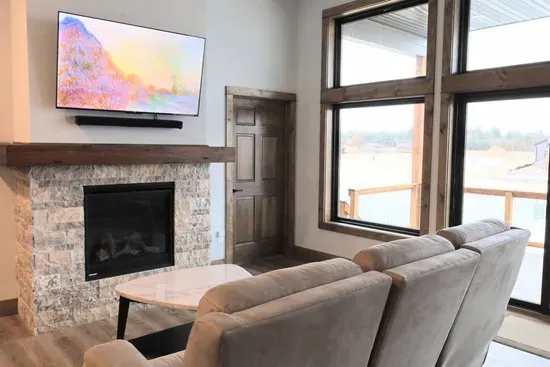 A peaceful living room with a view of the lake with direct access to the deck. (UPSTAIRS)

Simply flip a switch to turn on this cozy gas fireplace!