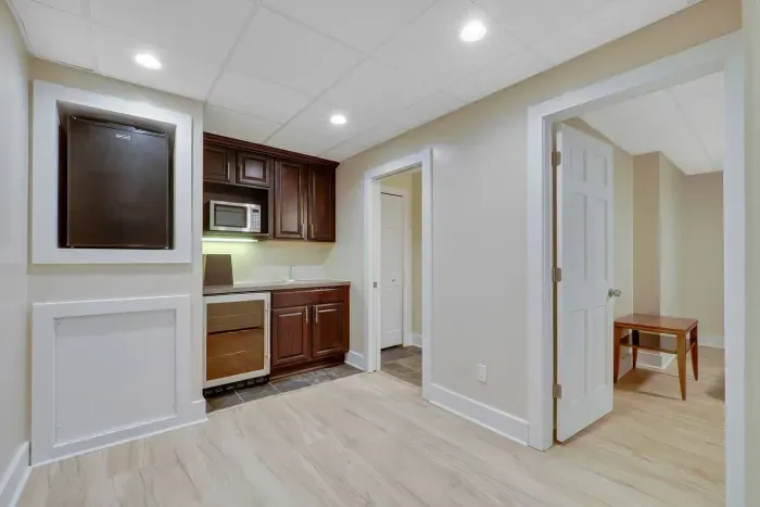 Lower level mini kitchen , small fridge, microwave, wine cooler, sink.