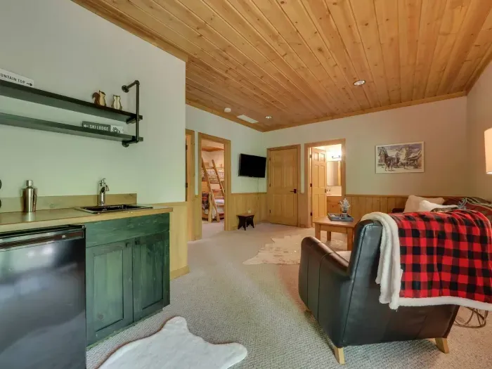 Lower living room with mini fridge and sink.