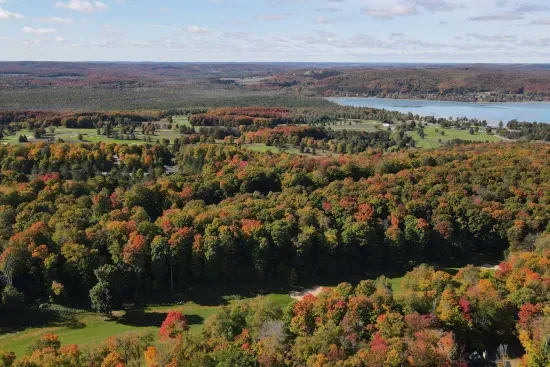 Drone photography taken directly above the property, showing golf nearby and Deer Lake 1/2 mile away.
