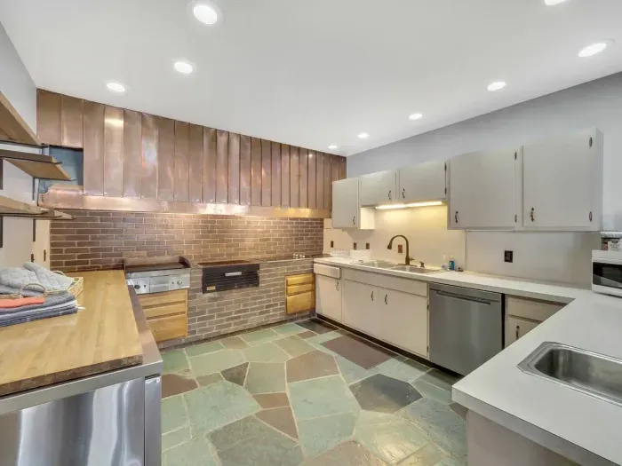 Lower Kitchen with copper hooded vent, and commercial griddle