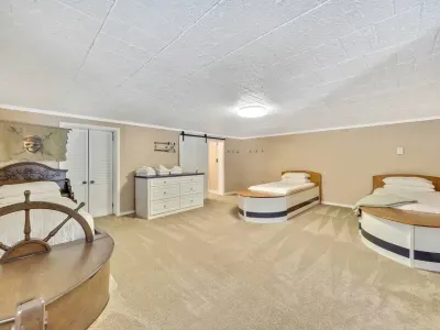 Boat bedroom on the lower level with three twins beds and three trundle beds - sleeps six;   barn door leads to full bathroom