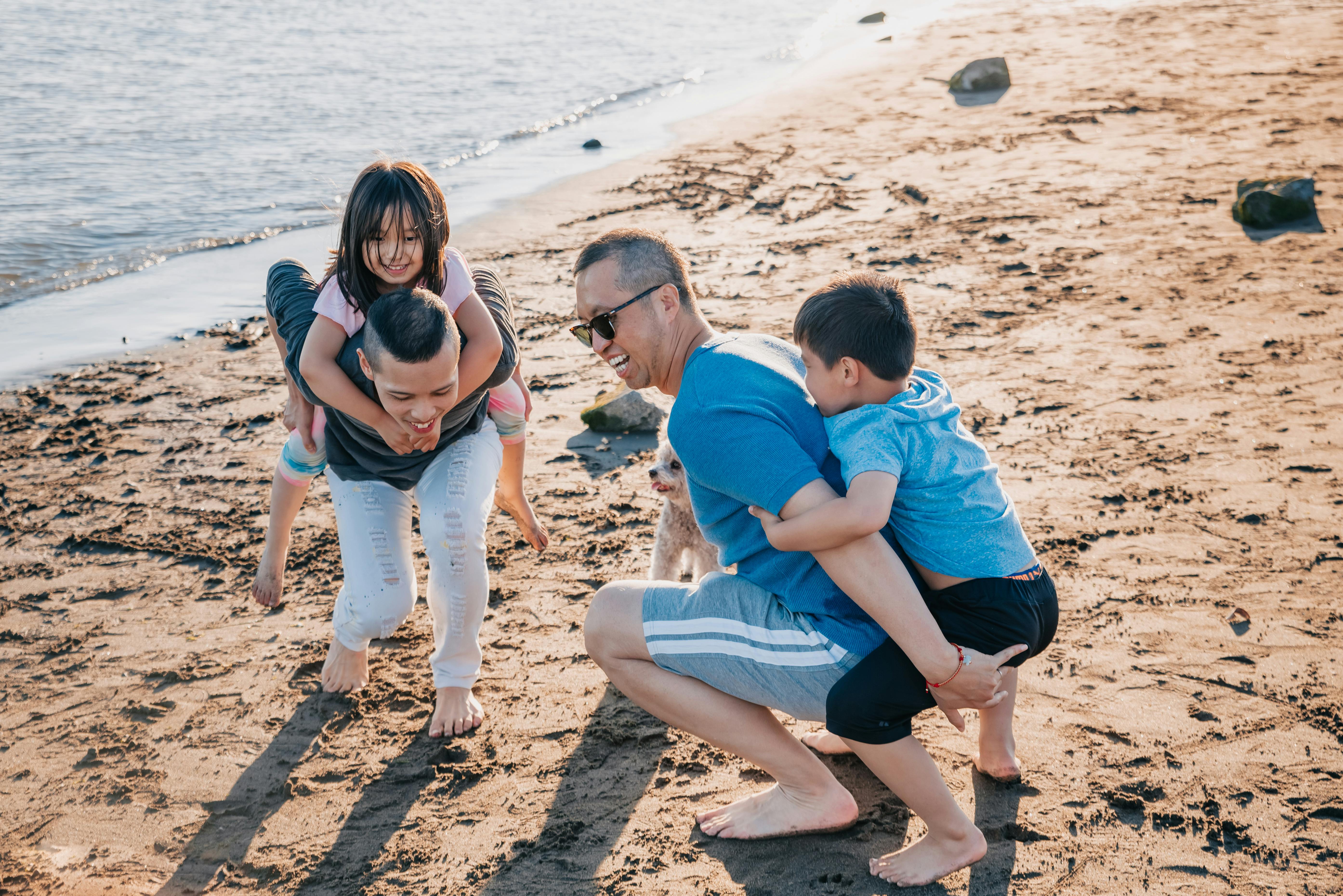 Father and children playing together on the beach during a Pacific View Lodging Oregon Coast getaway