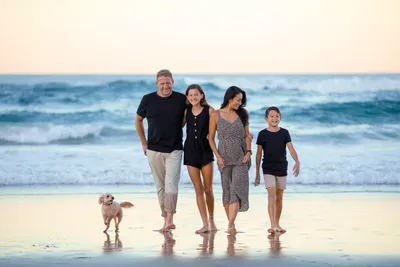 Family walking together along the Oregon Coast shoreline during a relaxing Father’s Day beach getaway