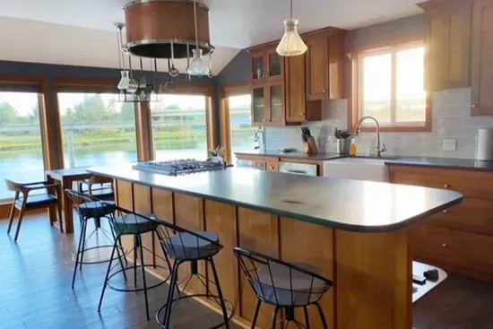 Modern, fully equipped kitchen with large island, gas stove, microwave, dishwasher and tons of cookware.