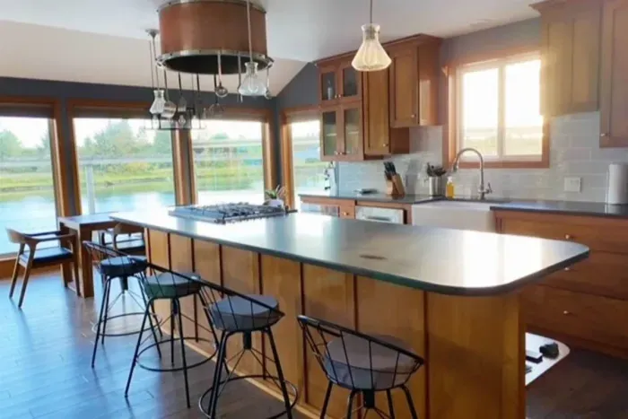 Modern, fully equipped kitchen with large island, gas stove, microwave, dishwasher and tons of cookware.