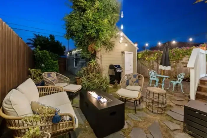 Cozy outdoor lounge with fire pit and string lights, creating the perfect evening gathering spot under the stars.