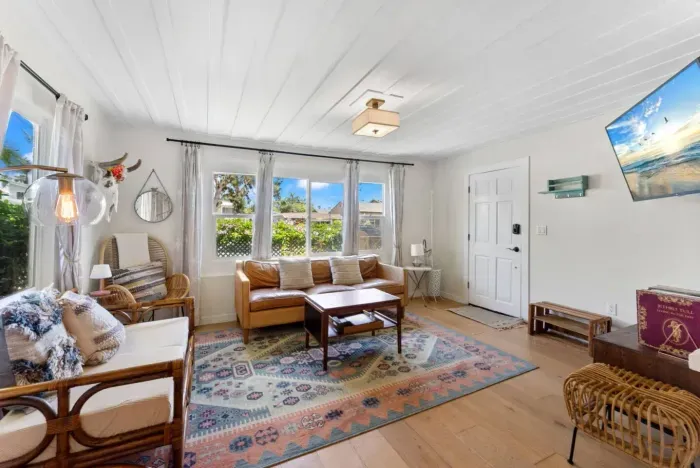 Bright boho-inspired living room with cozy seating, natural light, and eclectic charm.