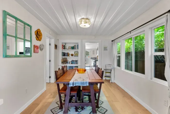 Charming dining room with seating for six, natural light, and eclectic decor accents.