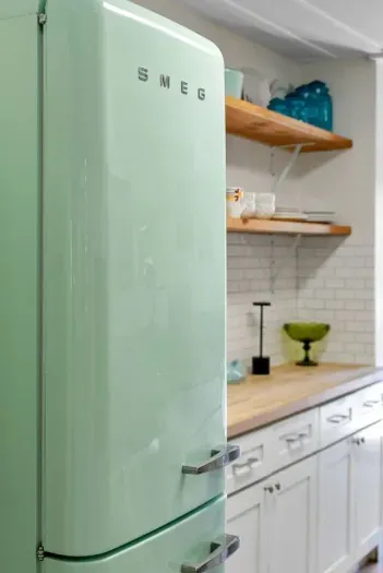 Retro mint-green SMEG fridge adds a playful pop of color and vintage charm to the kitchen.