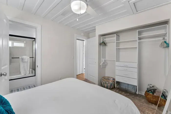 Airy bedroom with built-in closet storage and direct access to a modern bathroom for added convenience.