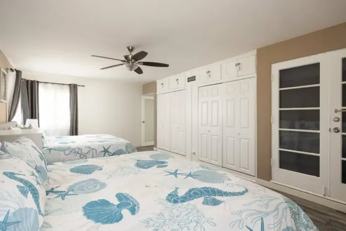 The large primary bedroom has closet space for your items, a ceiling fan, as well as a full length mirror for getting ready