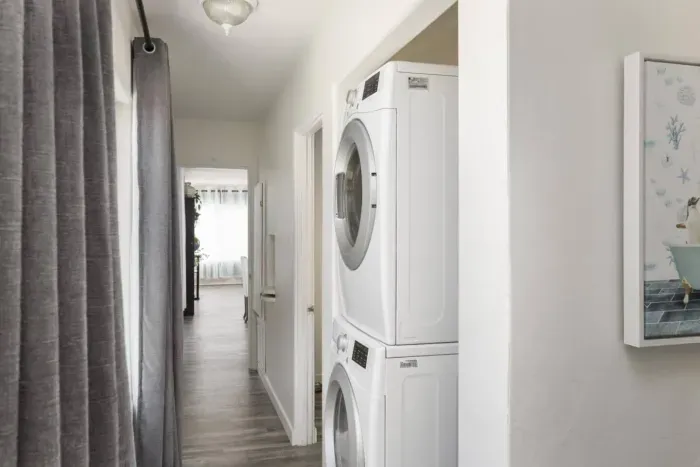 The laundry area is in the hallway between the two rooms