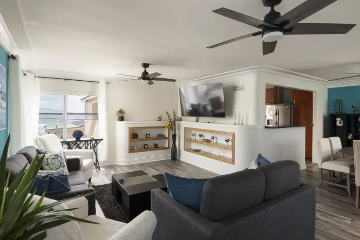 Living and dining area with large open space. Two sofas (one pull out bed size queen) and two arm chairs provide seating space for your whole group. A large smart TV allows you to stream your favorite shows while enjoying the breeze from the ocean!