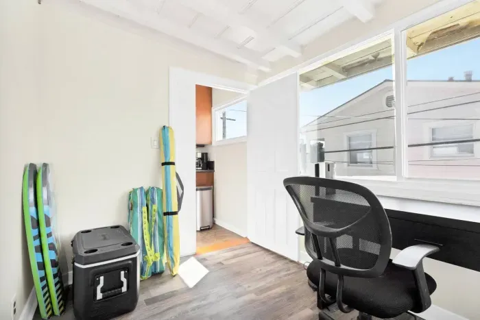 The small office/storage area has a desk and beach items, as well as a high chair