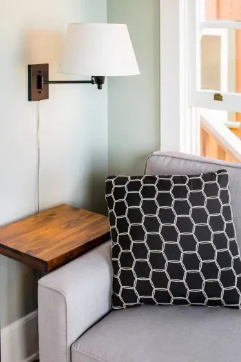 Cozy corner lamp and soft pillow on the sofa for relaxation.