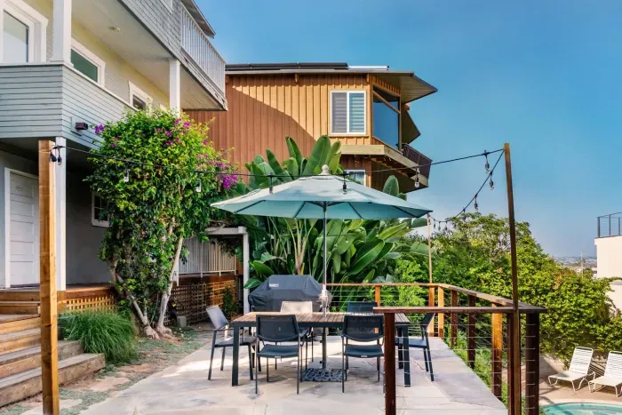 Outdoor patio dining area with Weber gas BBQ grill and sitting area with downtown and water views.