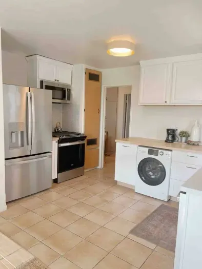 Kitchen with new appliances including gas range, dishwasher, fridge, microwave and combo washer/dryer