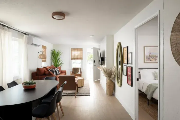 Bright and modern living space with cozy seating, dining for six, curated decor, and plenty of natural light.