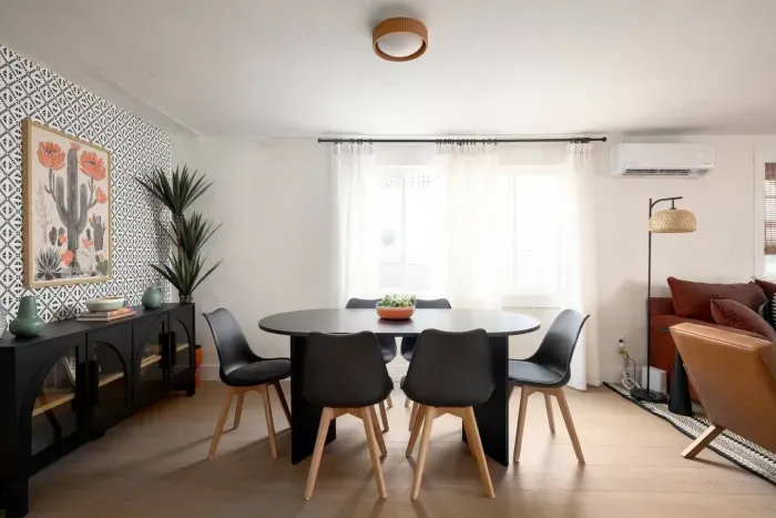 Bright dining area with seating for six, bold accent wall, and modern design—perfect for meals or game nights.