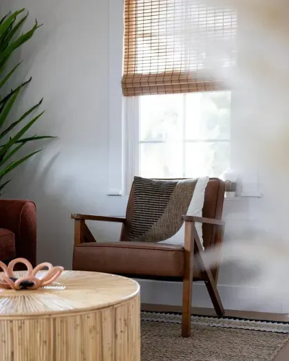 Inviting reading nook with natural light, warm textures, and a comfy accent chair.