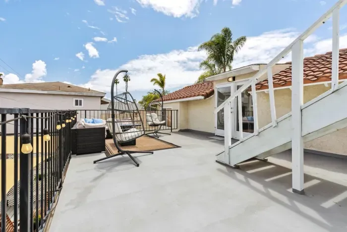 Expansive rooftop deck with seating and open skies.