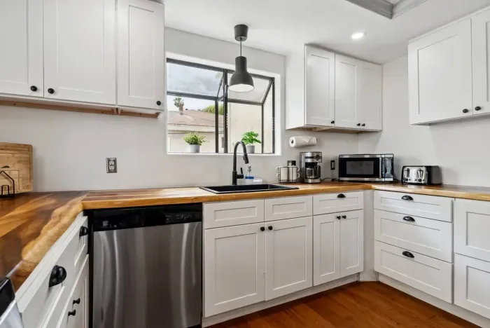 Functional kitchen with farmhouse sink and bright cabinets.