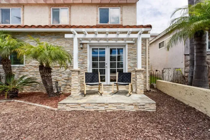 Entryway with palm-lined landscaping and tiered steps.