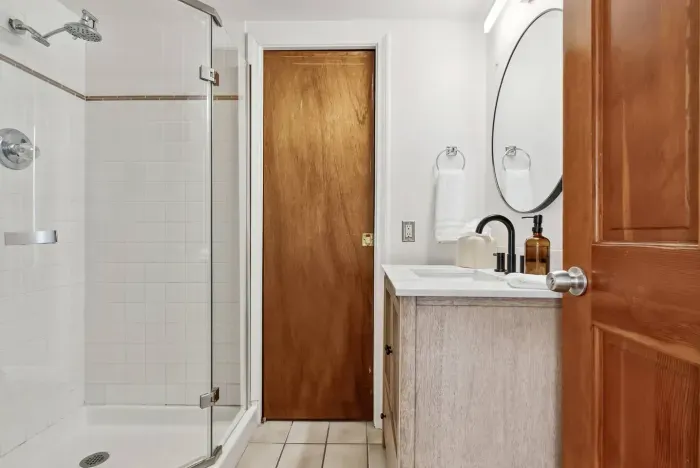 Updated bathroom with wood vanity and walk-in shower.