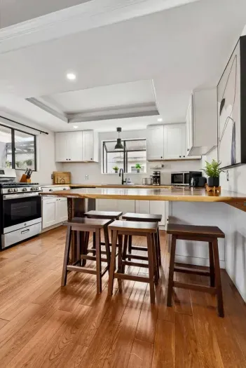 Chef-ready kitchen with natural light and bar seating.