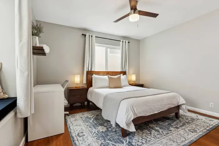 Peaceful bedroom with ceiling fan and natural light.