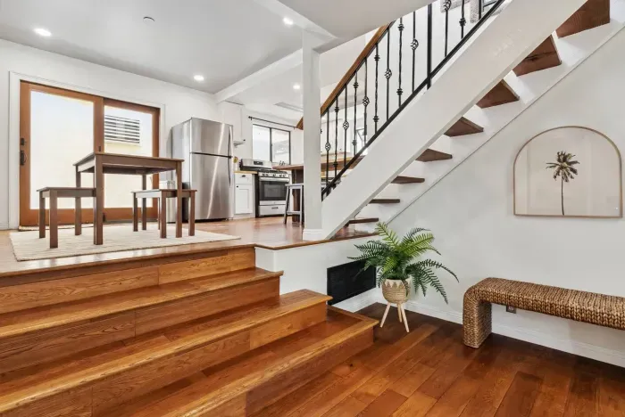 Dining area adjacent to modern staircase and open kitchen.