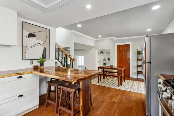 Modern kitchen with stainless appliances and wood dining table.