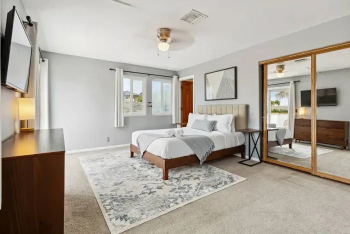 Spacious bedroom with cozy rug and natural tones.