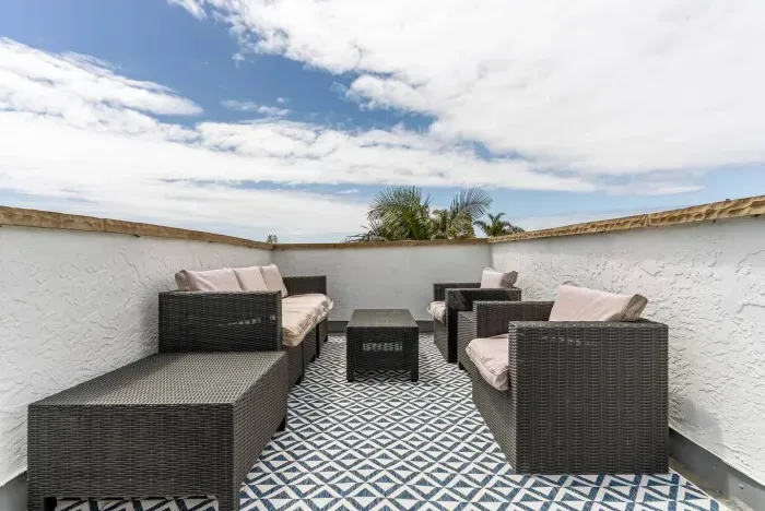 Modern backyard patio with stone pathway and palm trees.