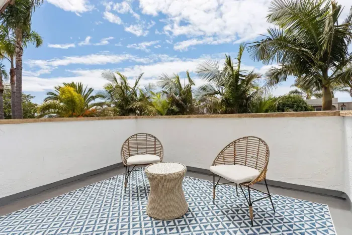 Balcony seating area with patterned tile floor.