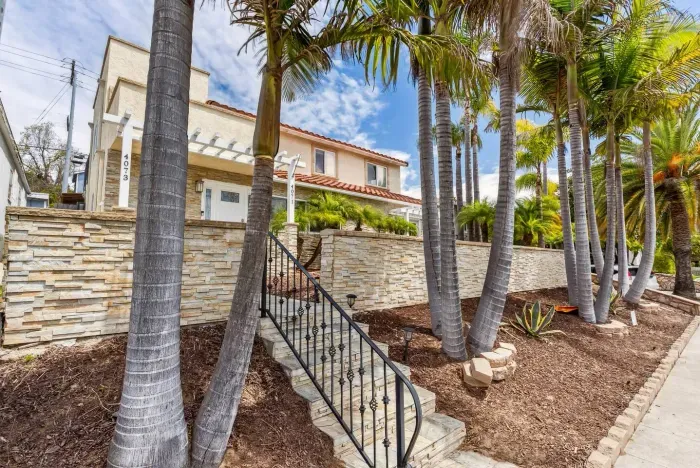 Palm-lined front entry with stone steps.